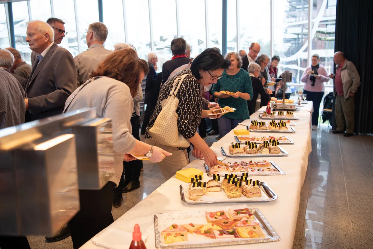 Drinnen gab es ein kaltes Buffet. Man sieht Personen am Buffet.